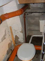 oben die Regenwasserableitung unten das Rohr der Fäkalienableitung und neue Toilette